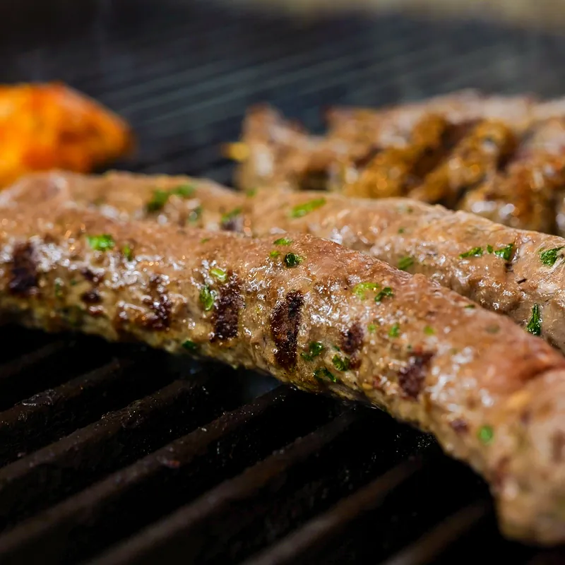 Kofta kabobs of seasoned ground beef on the grill